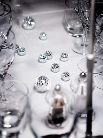 Instead of flowers, miniature disco balls decorate the table setting for Copenhagen Island Hotel’s “White Christmas” theme event. White porcelain and clear crystal glasses send associations to snow and ice.